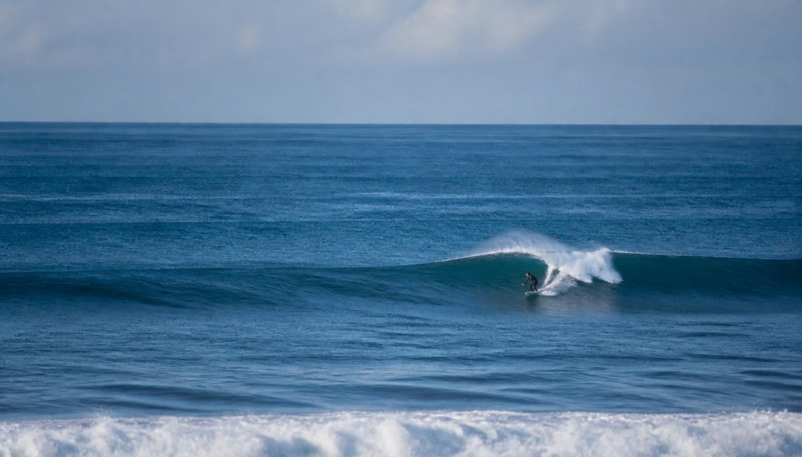 Surfer mit Boards am Strand eines Surf Camps in Spanien